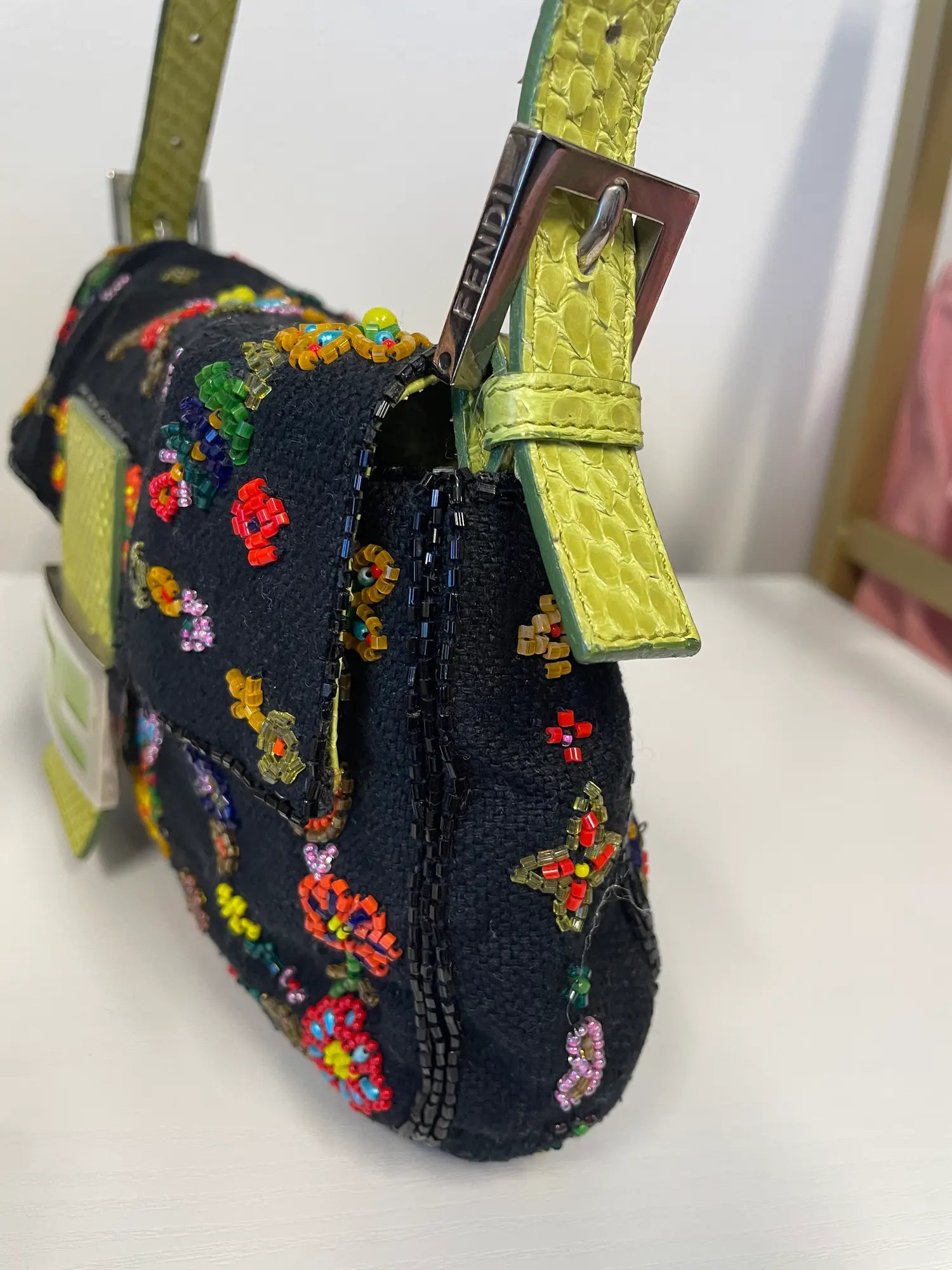 Side view of Fendi beaded baguette showing python strap and hardware.