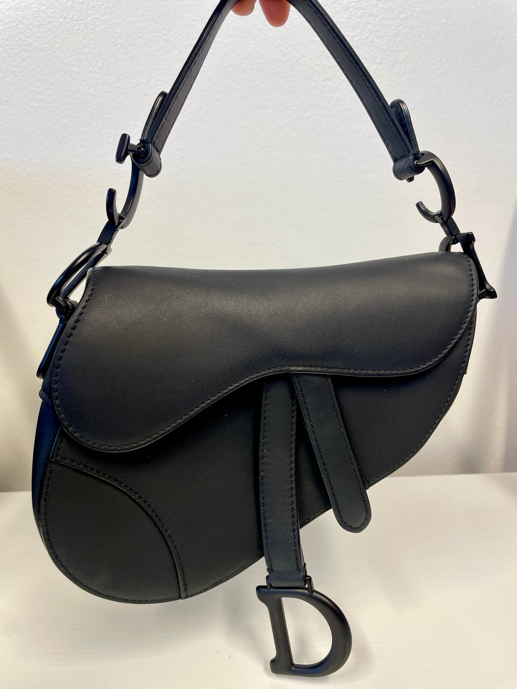 Dior Saddle Bag in Black Ultramatte Calfskin with adjustable strap.