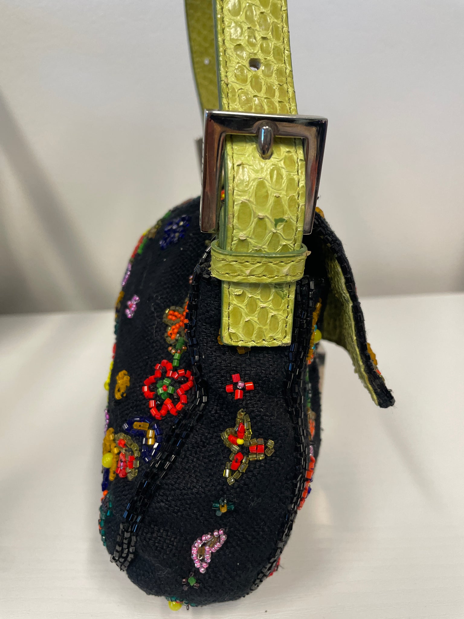 Side view of Fendi beaded baguette showing python strap and hardware.