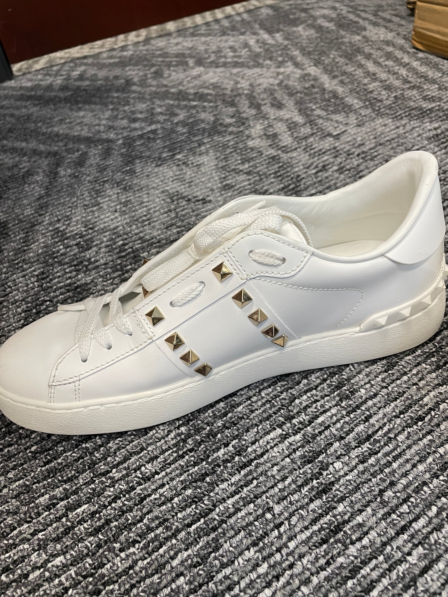 Side profile of Valentino Untitled Rockstud Sneakers – luxury white leather with studs