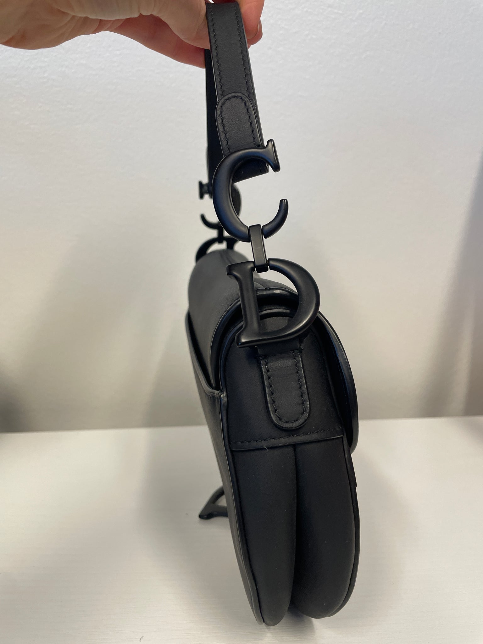 Close-up of Dior “CD” hardware on handle and D stirrup clasp.