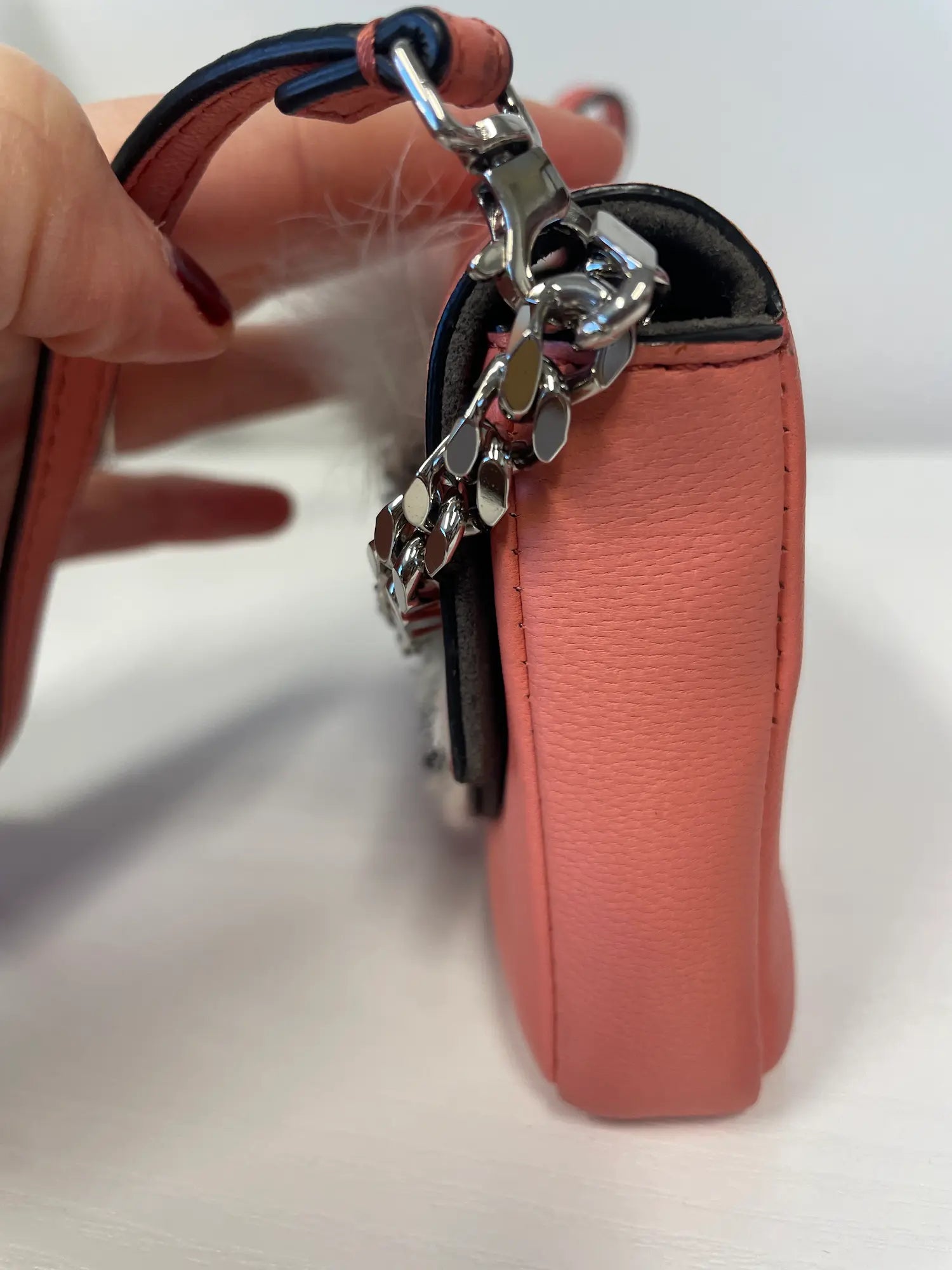 Side view showing adjustable crossbody strap and silver hardware.