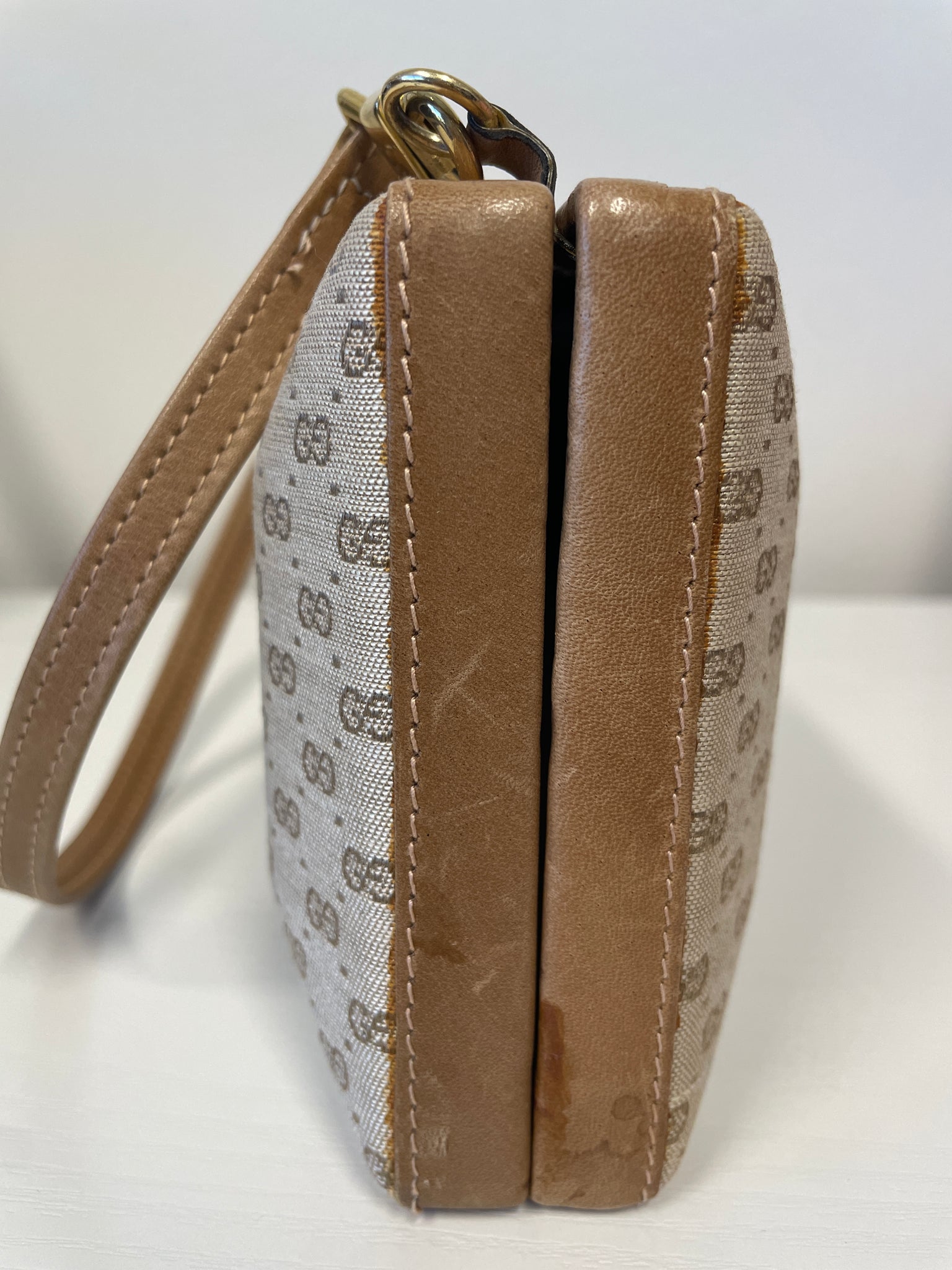 Side profile of Gucci vintage monogram box clutch in beige and brown.