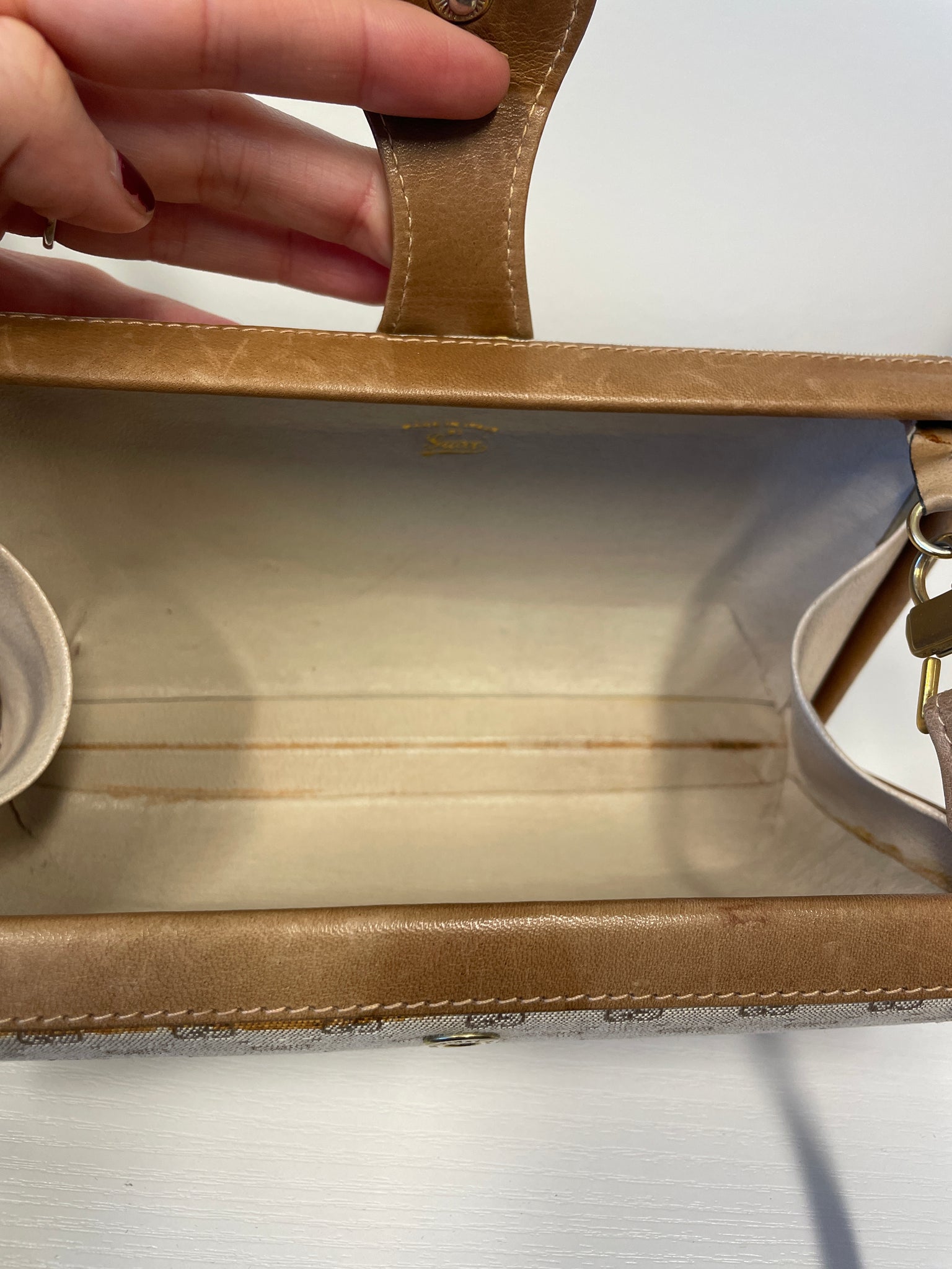 Interior of Gucci clutch showing fabric lining and zip closure.