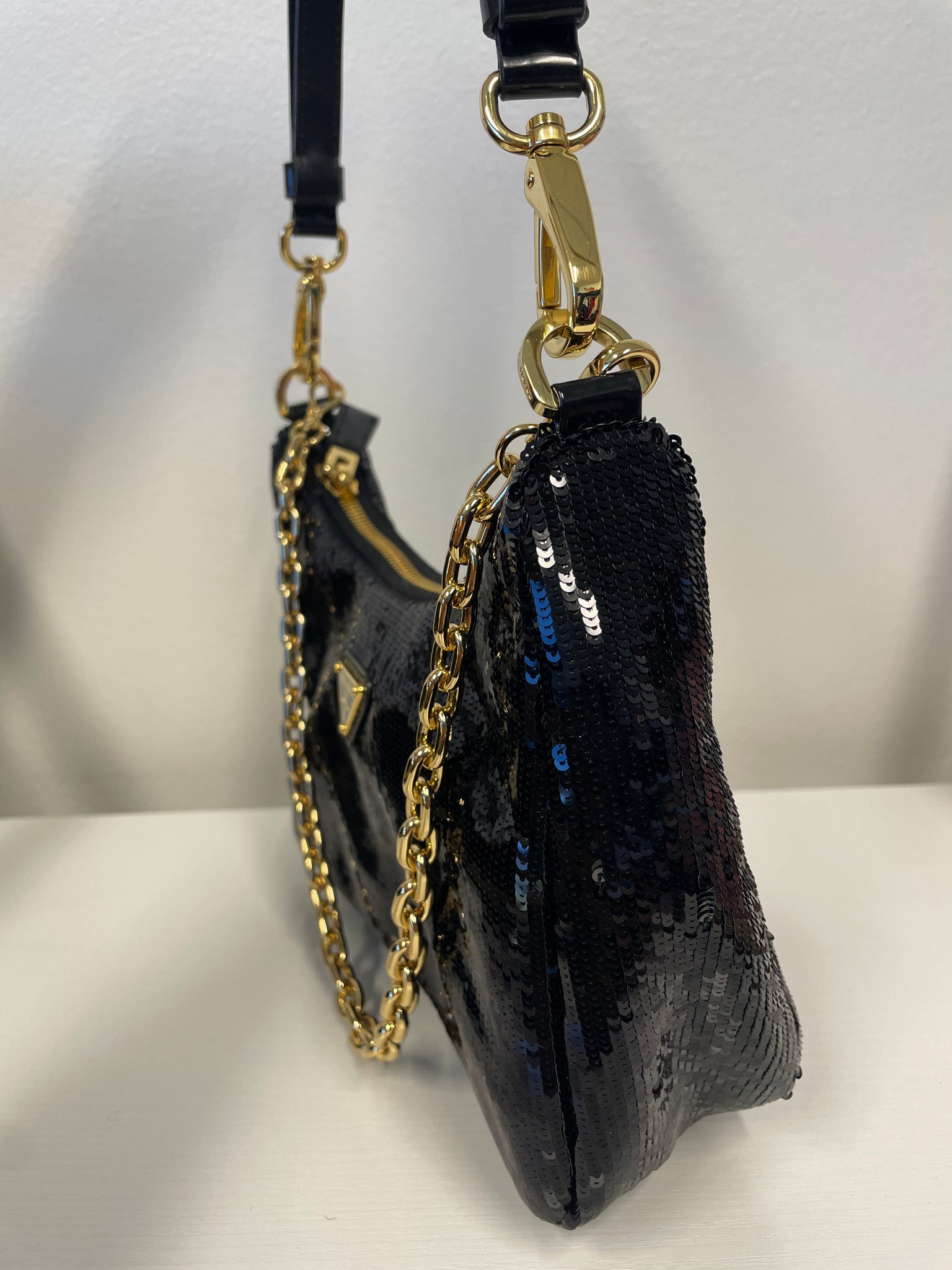 Side view of Prada black sequined Re-Nylon mini bag with detachable strap.