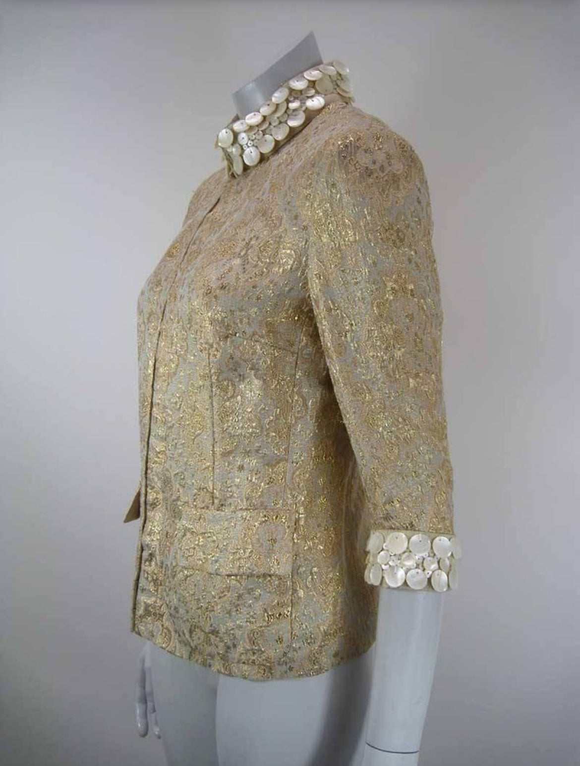 Side profile of Dolce & Gabbana vintage gold jacket with pearl details.