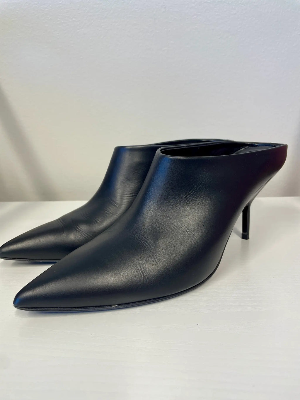 Side view of Pierre Hardy black leather pointed toe mules.