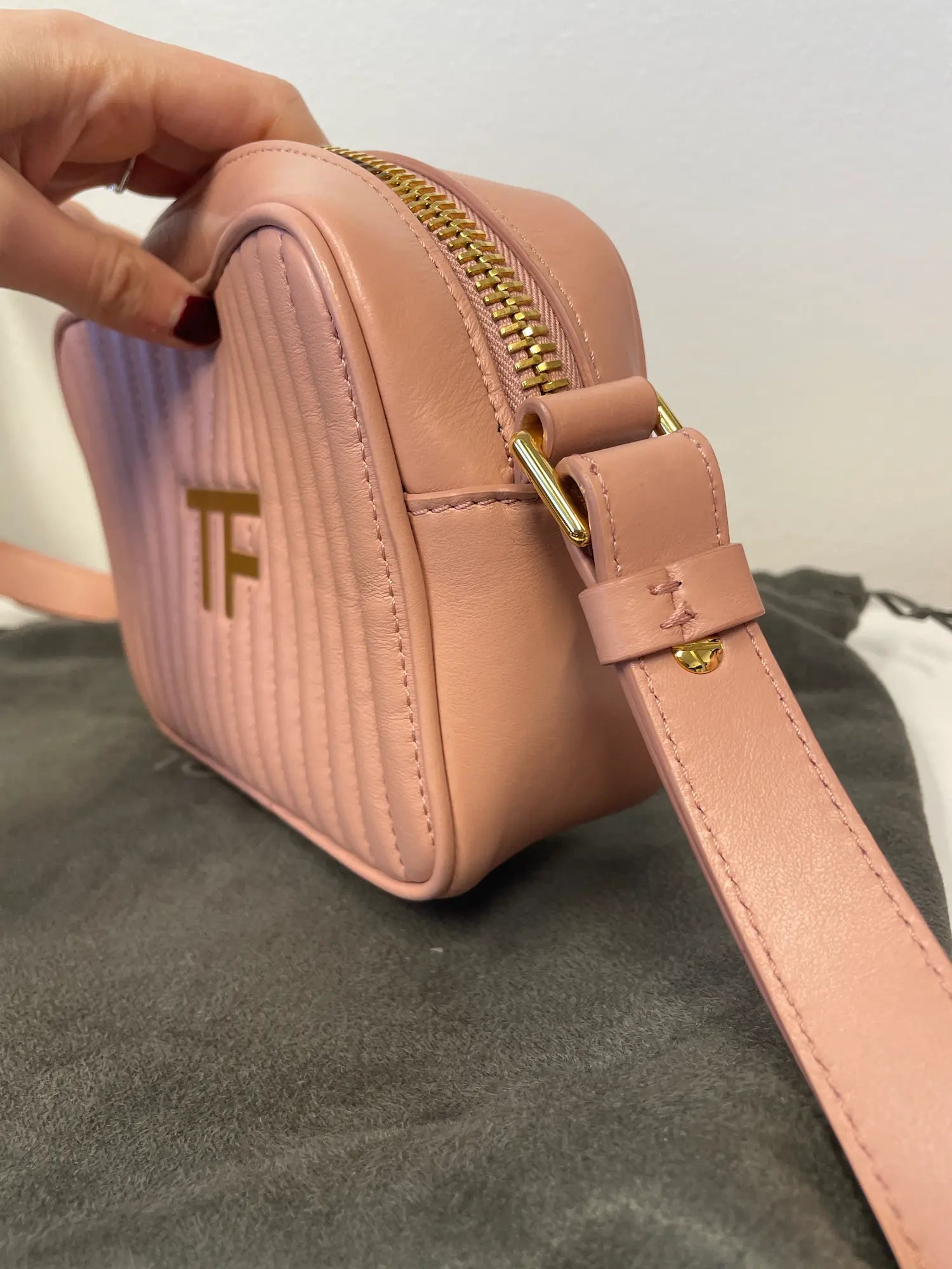 Side view showing adjustable strap and gold TF logo detail.