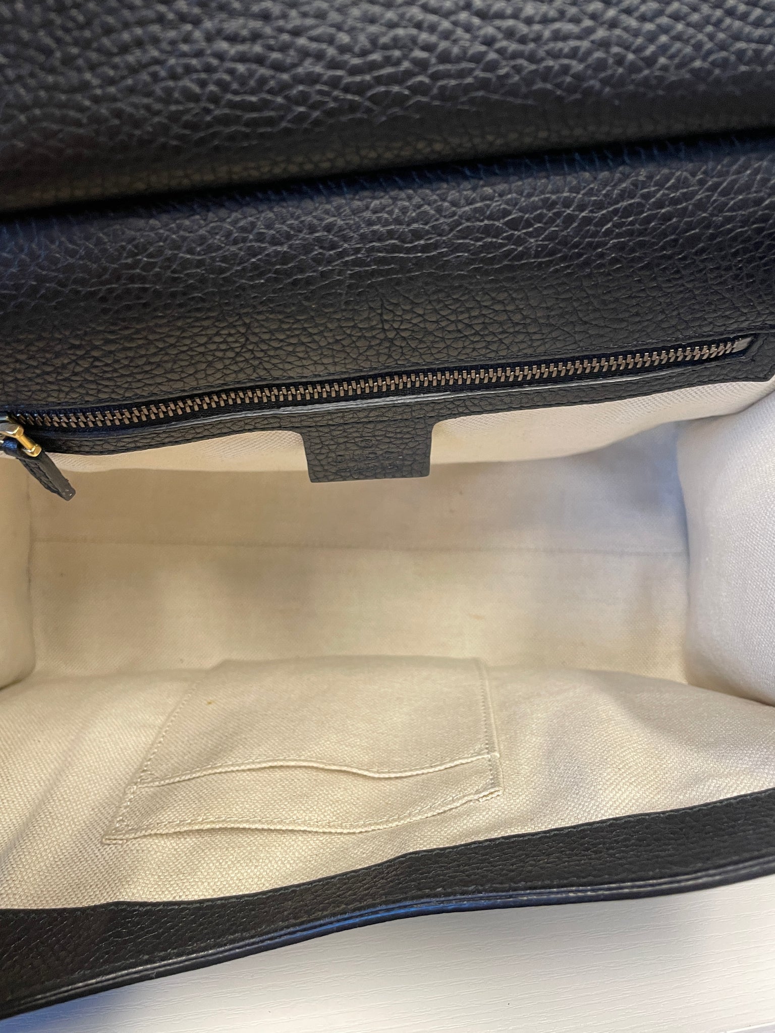 Interior view of Gucci Marmont handbag showing beige fabric lining.